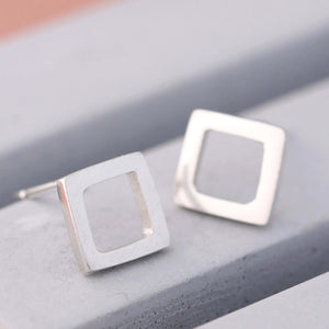 Polished square silver stud earrings on grey dish, classic square stud earrings