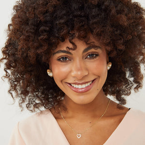 Model wearing luxury 9ct gold pearl earrings with polished gold domes