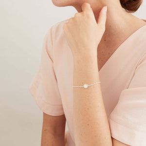 Handmade ladies pearl bracelet styled with a white blouse, highlighting the delicate sterling silver chain for everyday wear.