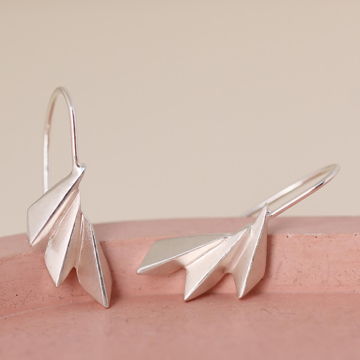 Pink dish display of sterling silver art deco drop earrings with concertina fan shape; elegant gift for brides, friends or jewellery lovers.