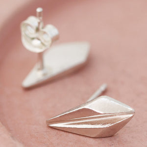 Pair of silver art deco stud earrings on a pink dish, showing the elegant ridged design of these art deco style earrings suited for bridesmaids or special occasions.