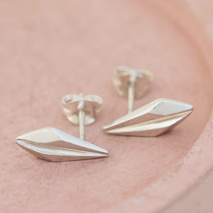 Product close-up of art deco style earrings on a pink dish, demonstrating the refined silver geometry ideal for brides, bridesmaids, and special celebrations.