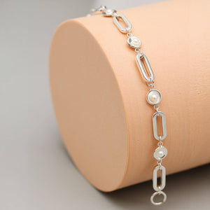 Close up of a handmade sterling silver pearl chain bracelet highlighting polished pearl settings and genuine freshwater pearls.