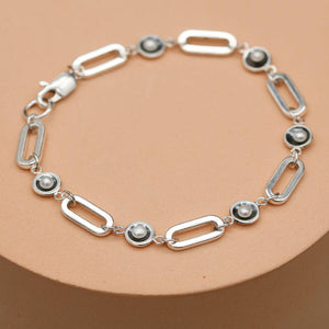 Handmade black pearl chain bracelet featuring five genuine freshwater pearls in oxidised sterling silver settings on a bold sterling silver chain.