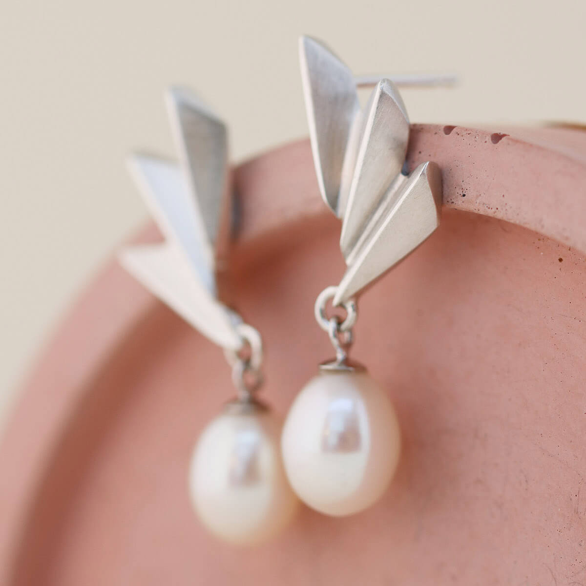 Close-up of Art Deco pearl earrings highlighting the geometric silver fan and freshwater pearl, perfect sterling silver drop pearl earrings for weddings.