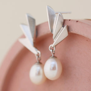 Close-up of Art Deco pearl earrings highlighting the geometric silver fan and freshwater pearl, perfect sterling silver drop pearl earrings for weddings.