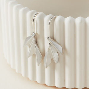 Art deco drop earrings on a white dish showing the crisp geometric fan design; perfect fan drop earrings for wedding day jewellery gifts.