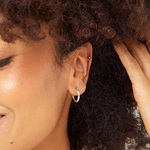 Model wearing silver hoop stud earrings, sterling silver hoop earrings for women with a modern minimalist look