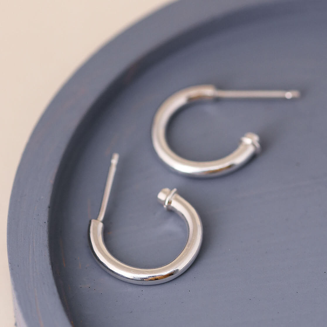 Silver hoop earrings without charm on a blue dish, minimalist sterling silver charm hoops worn as classic everyday hoops