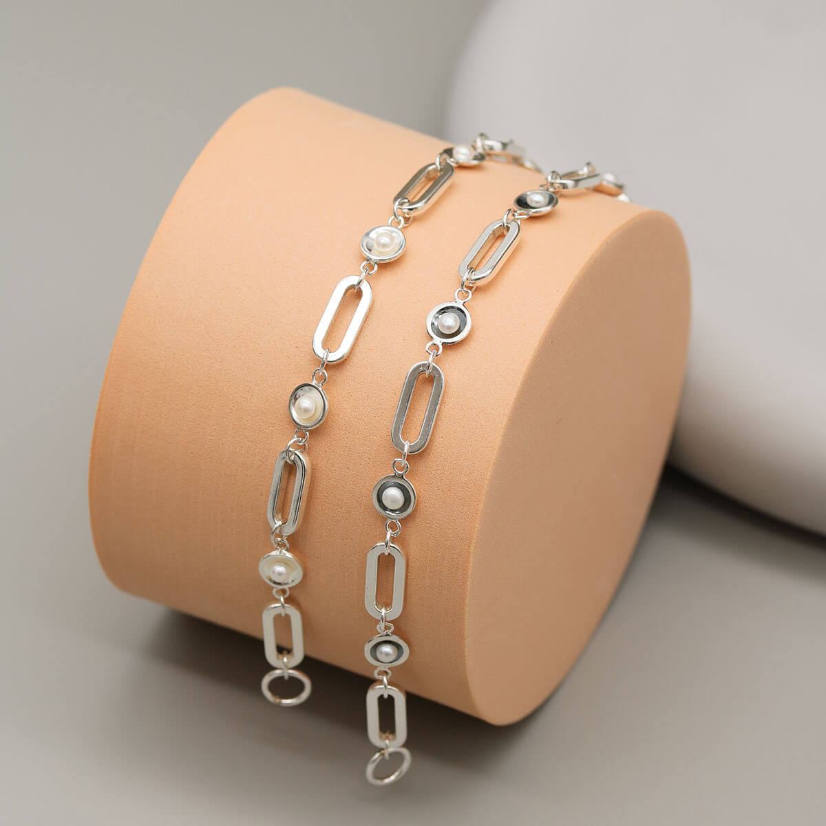 Black and sterling silver pearl chain bracelets displayed together, showcasing polished and oxidised pearl settings with genuine freshwater pearls.