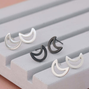 Silver moon earrings in polished, matte and oxidised finishes on grey dish