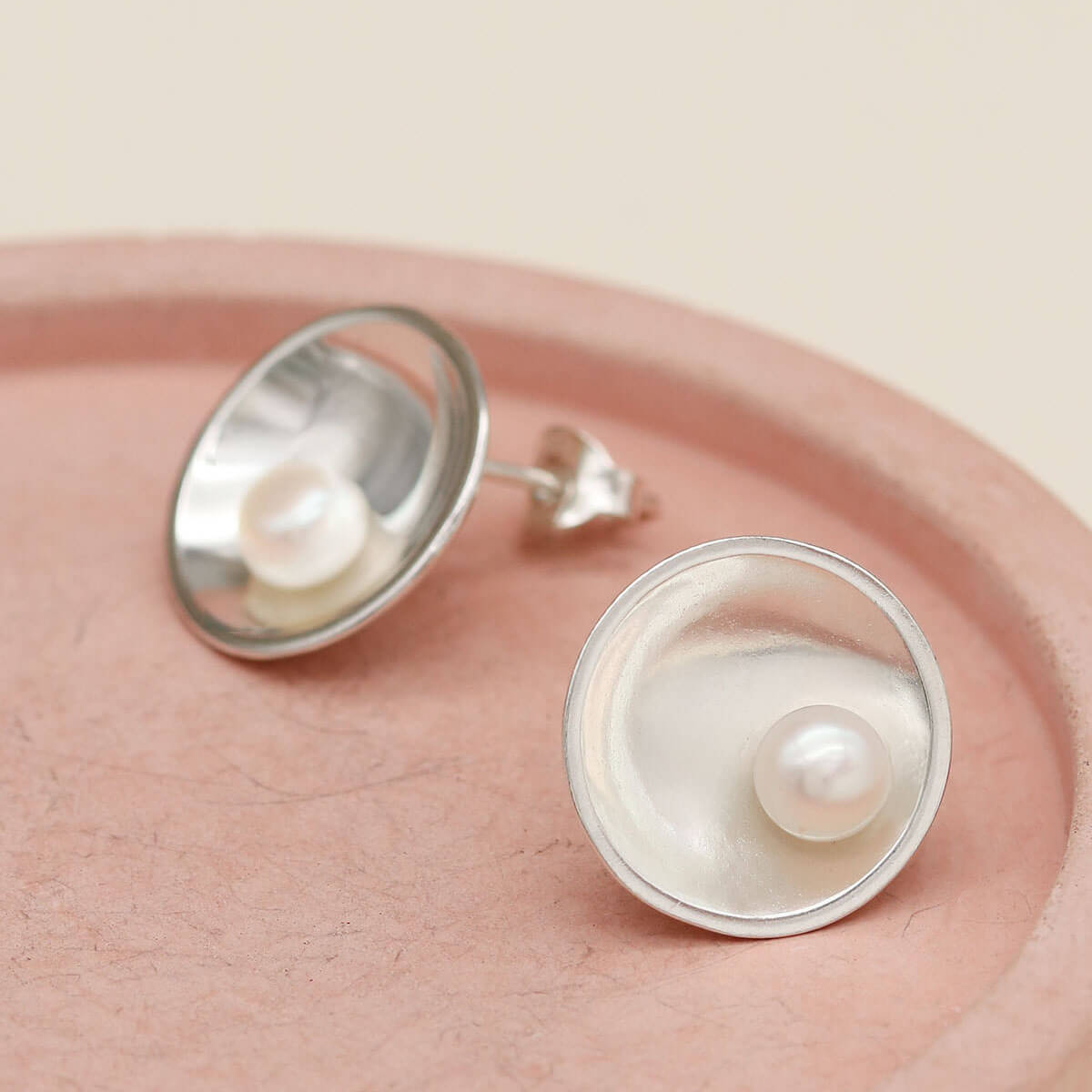 Signature sterling silver pearl earrings showcasing polished sterling silver and naturally lustrous freshwater pearls.