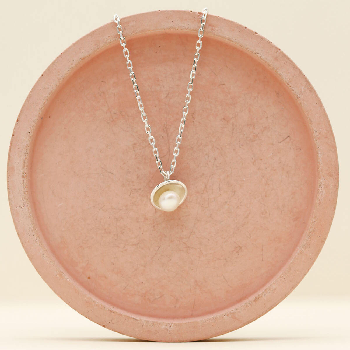 Detail of a handmade silver pearl pendant necklace highlighting the lustre of the genuine freshwater pearl and polished silver finish.