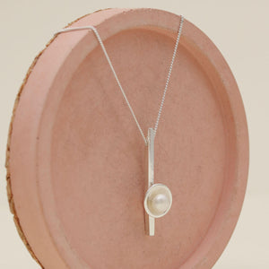 Elegant sterling silver pearl bar necklace showcasing a polished silver bar and 5mm freshwater pearl.