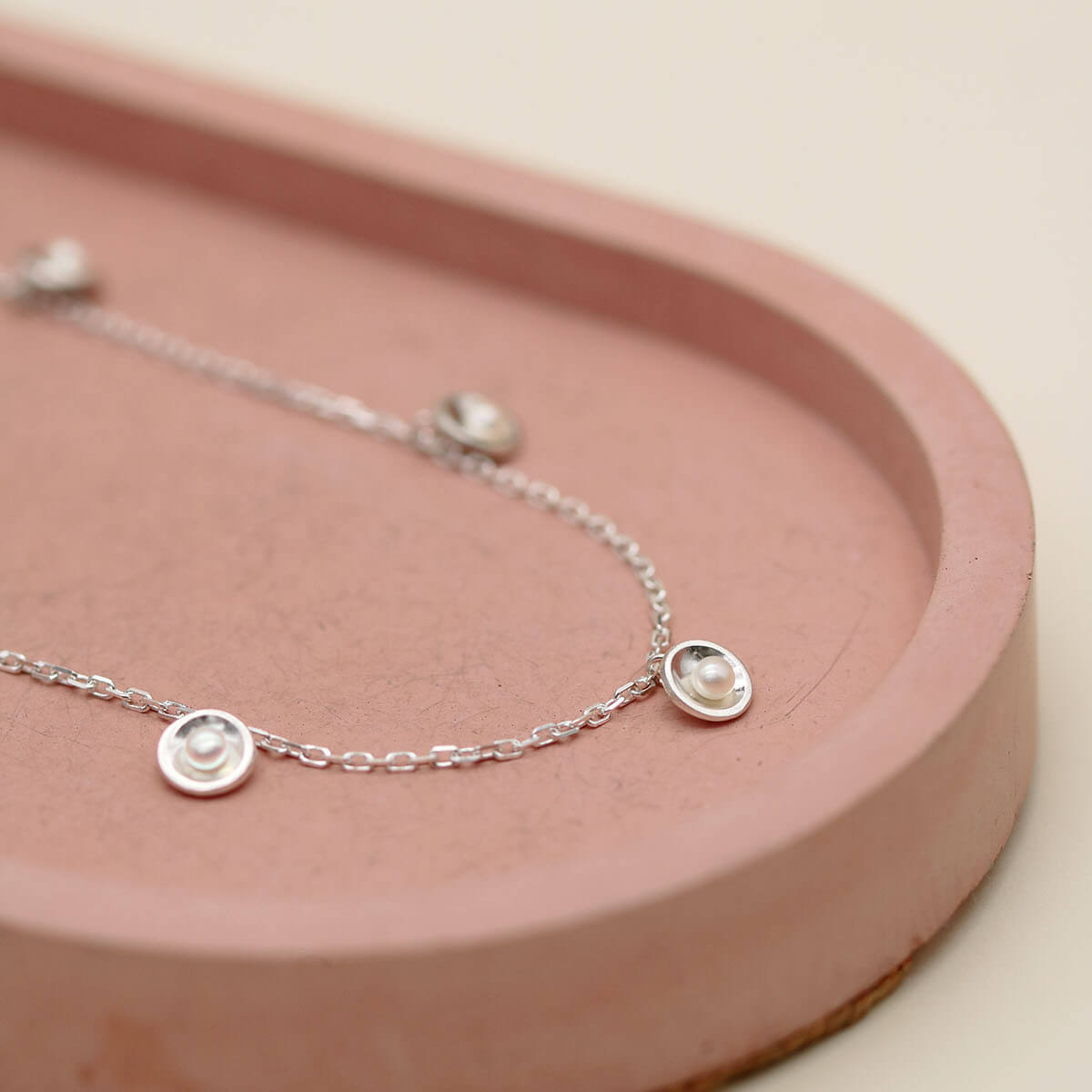 Delicate pearl chain necklace featuring five evenly spaced freshwater pearl stations on an adjustable sterling silver trace chain.