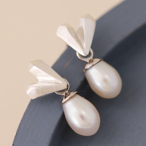Heart pearl earrings photographed on a blue dish, dainty sterling silver heart studs with pearl drop, ideal silver wedding earrings