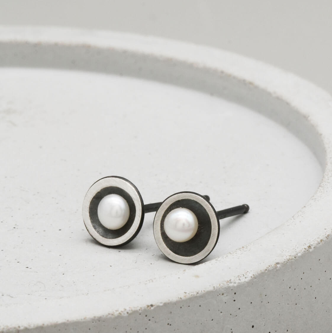Close-up of Petite Tiny Pearl Stud Earrings featuring handcrafted oxidised sterling silver and genuine 3mm freshwater pearls.