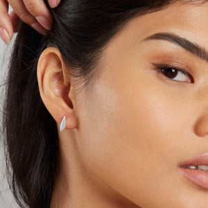 Small sterling silver stud earrings worn in a second piercing, delicate kite-shaped studs for everyday wear