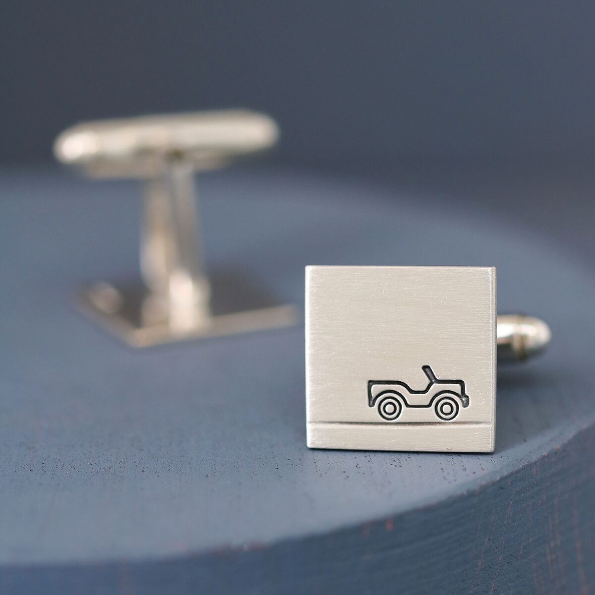 Pair of Car cufflinks presented together on deep blue background, a modern keepsake gift for car lovers and ideal anniversary present for him.