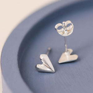Silver heart stud earrings on blue dish showing faceted love heart earrings for everyday wear and birthdays