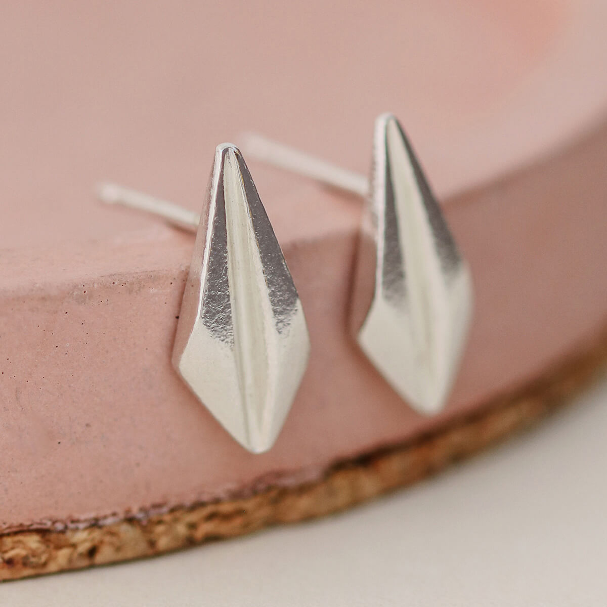 Elegant art deco stud earrings on a pastel pink dish, highlighting the streamlined geometric design, suitable for gifting on birthdays or as thank-you presents.