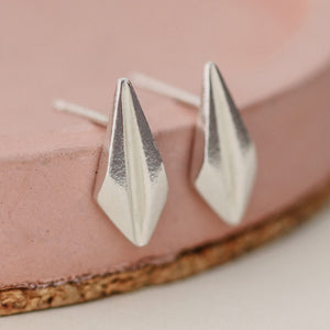 Elegant art deco stud earrings on a pastel pink dish, highlighting the streamlined geometric design, suitable for gifting on birthdays or as thank-you presents.