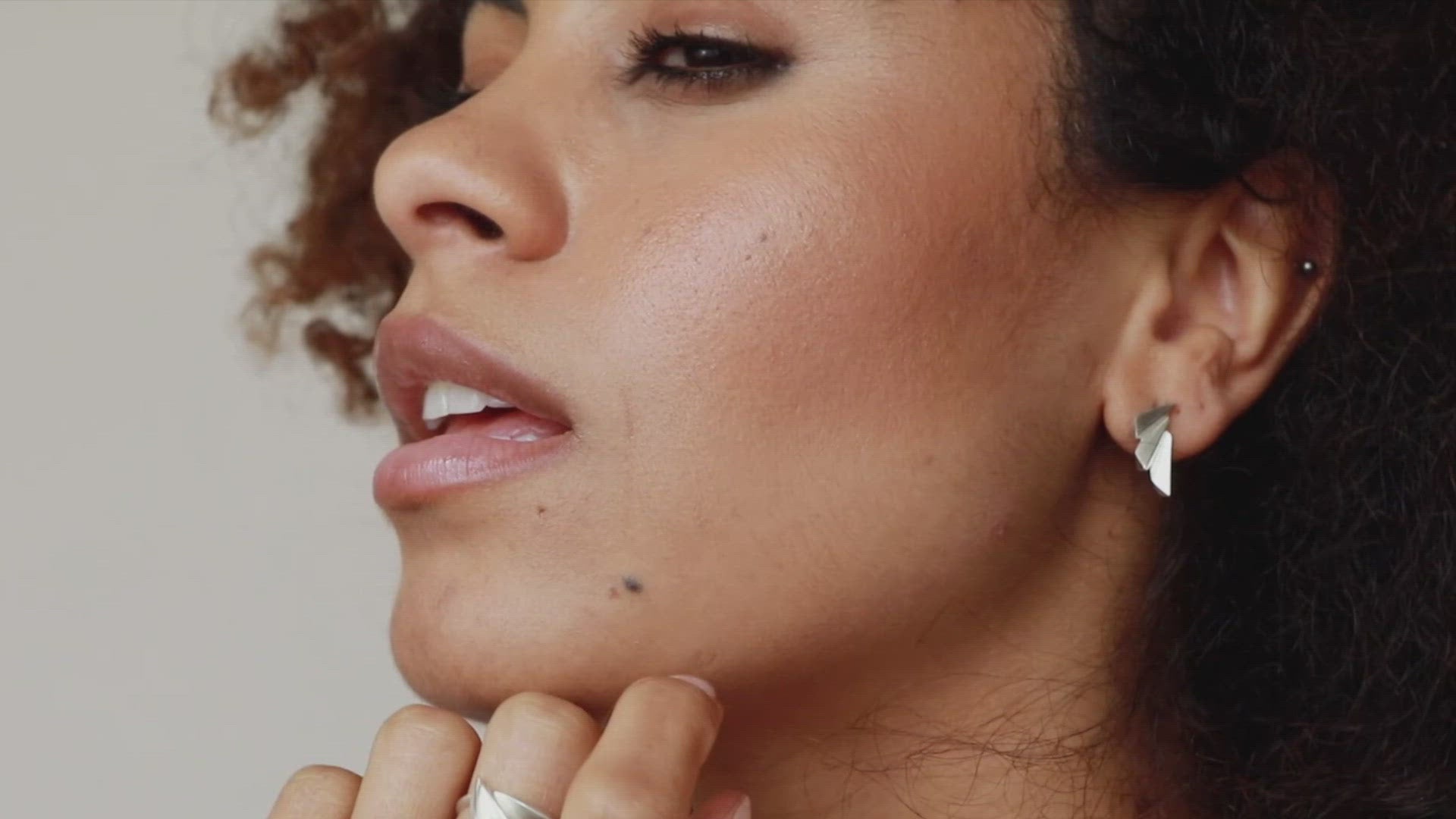 Video of model wearing art deco silver earrings, showing the fan design from multiple angles as the earrings catch the light.