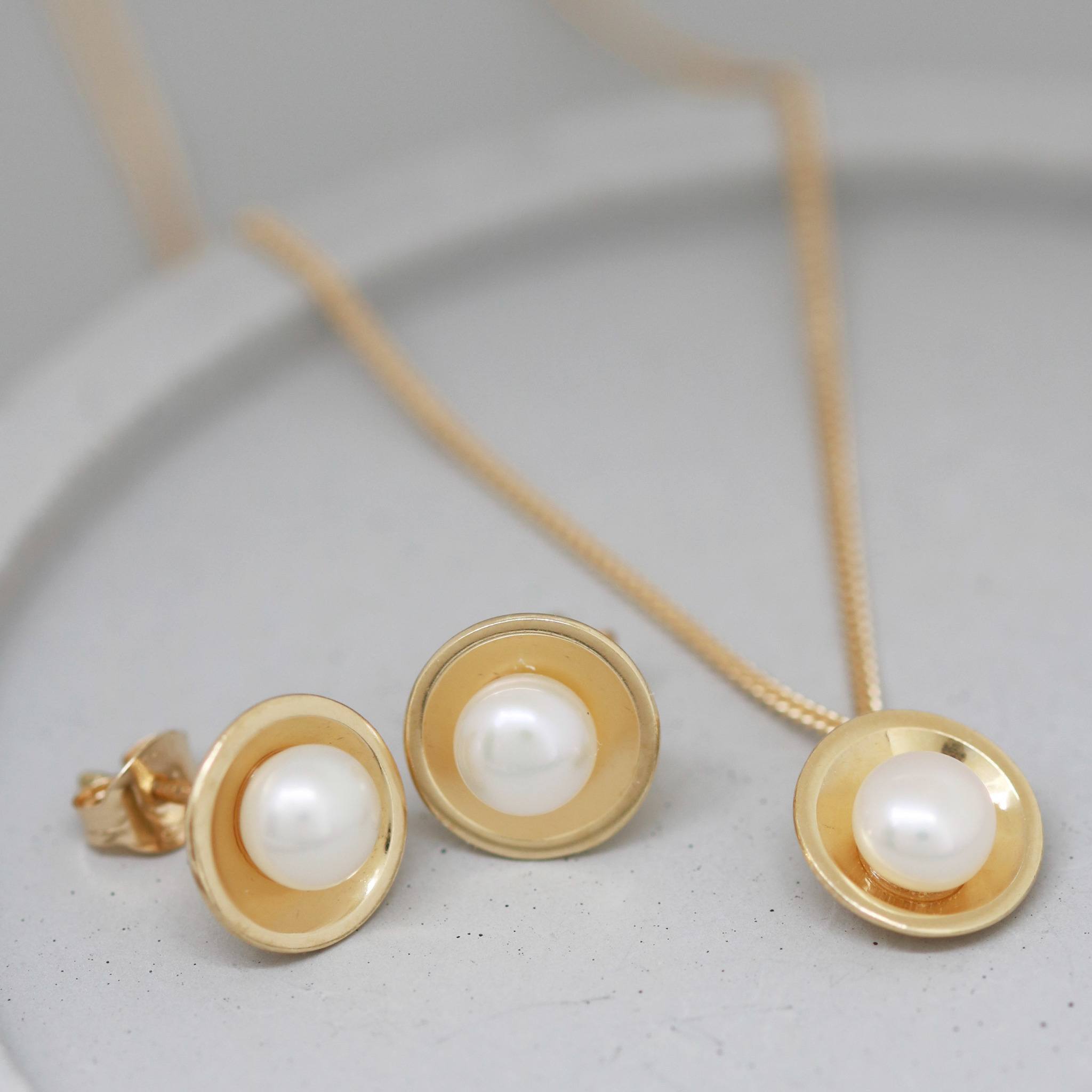 Handmade 9ct gold pearl pendant displayed with matching freshwater pearl stud earrings in solid 9ct yellow gold.